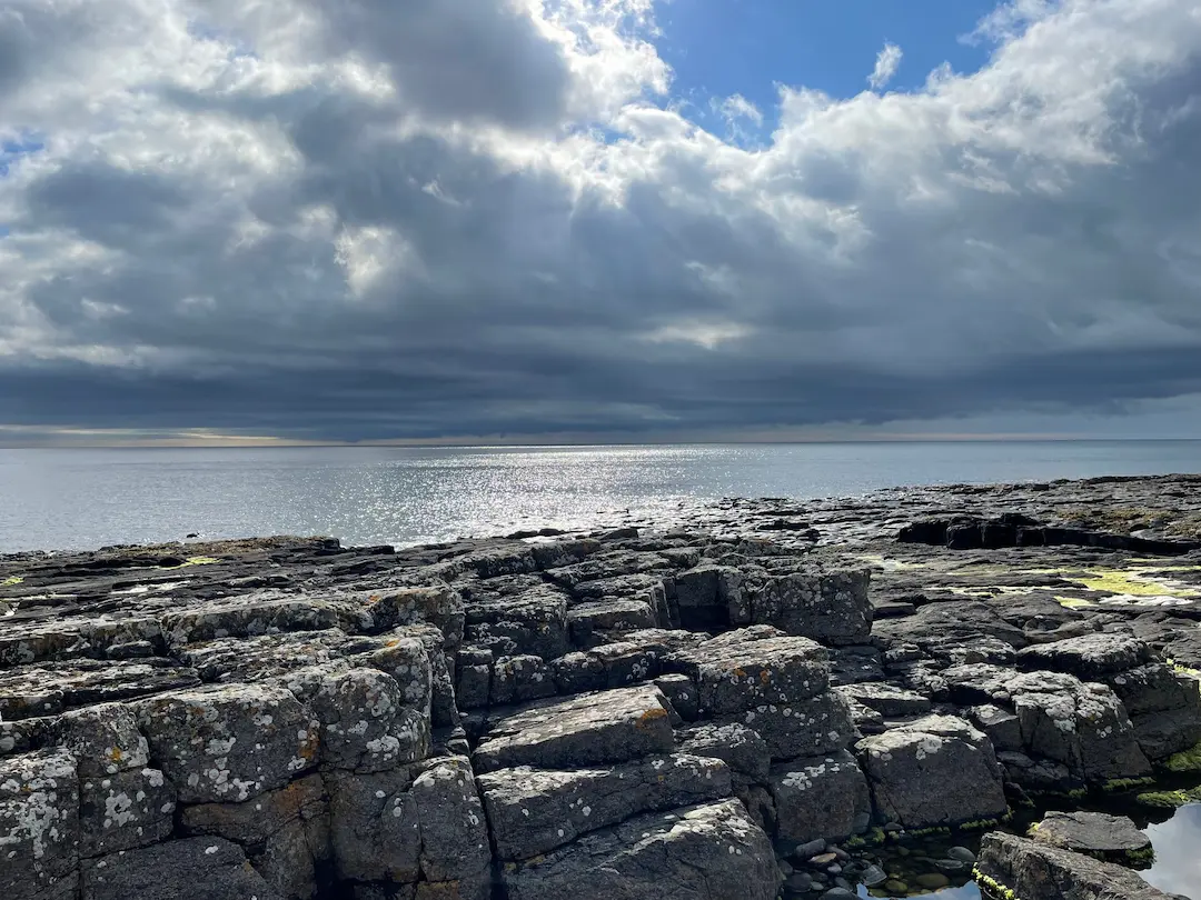 Light breaking through dramatic clouds onto the North Sea, Northumberland coast